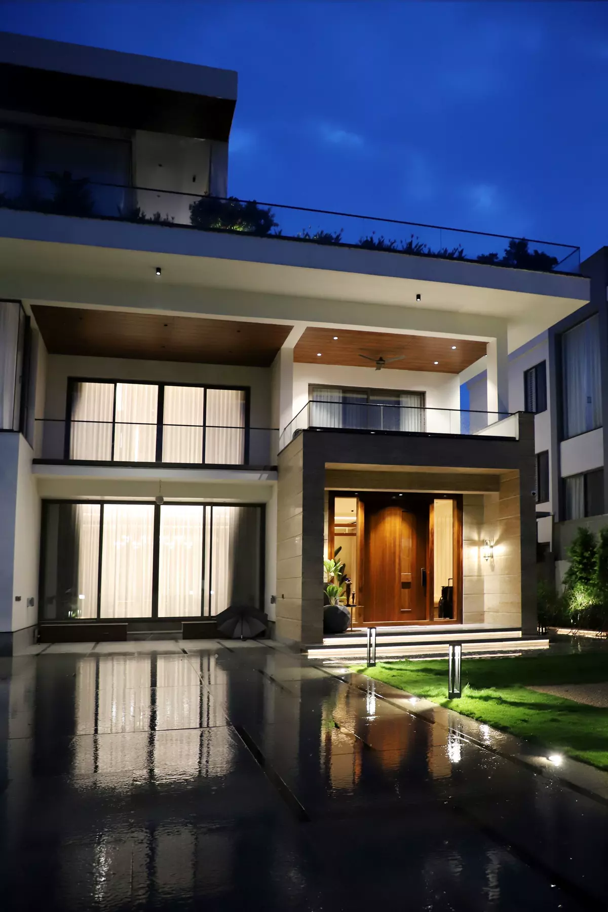 Villa de lujo al anochecer con la entrada iluminada en tonos cálidos